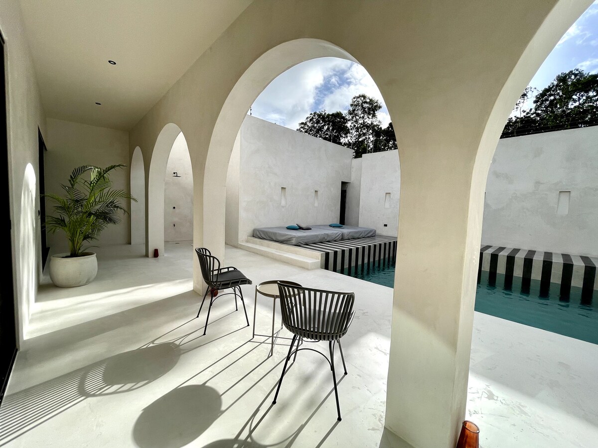 Casa Bali spacious king-size bedroom with minimalist decor and jungle views in Tulum rental villa